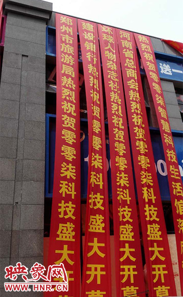 路邊一棟樓上懸掛著二三十條紅色條幅，全部是祝賀一家公司開(kāi)業(yè)的。