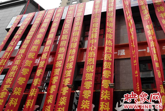 路邊一棟樓上懸掛著二三十條紅色條幅，全部是祝賀一家公司開(kāi)業(yè)的。