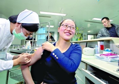 昨日，向雪敏在同濟醫院血液科病房打動員劑，丈夫陳武右在身后注視著妻子 記者傅克強