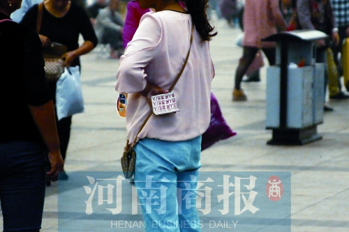 火車站廣場(chǎng)，一女子拿著寫有不同房型價(jià)位的卡片在拉客，不少市民抱怨，受過此類“騷擾”