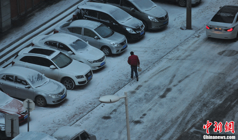11月18日，行人在沈陽街頭的積雪中穿行。