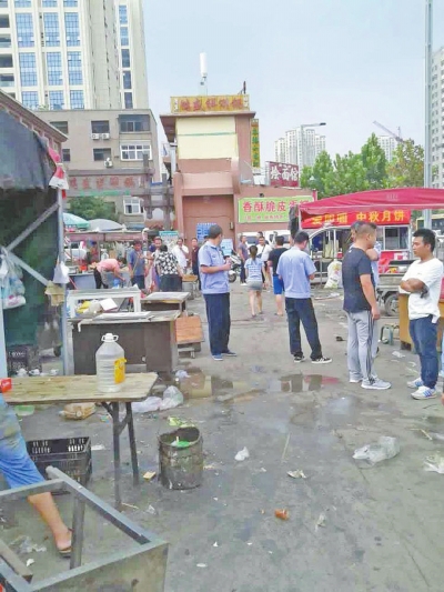 昨天，執(zhí)法人員在京廣路長(zhǎng)江路口整治“僵尸圍擋”及圍擋內(nèi)的攤販。