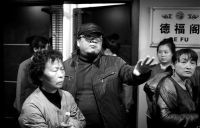 昨日，在河北香河天下第一城，相關(guān)負責(zé)人（左二）走出會議室與參加演出的老人們溝通。