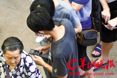 排隊的“黃?！备魇謭桃化B白紙，上面寫好了要掛號的人的信息，包括姓名、電話、要掛的科室等。穿黑白花紋衣服的老婆婆正在排隊掛號