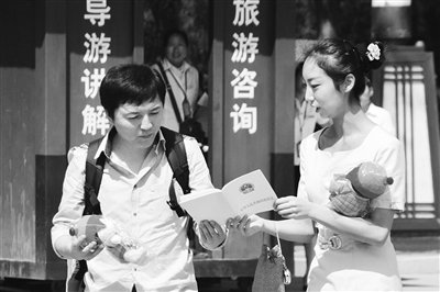 9月13日，西安臨潼華清池景區服務人員向游客介紹《旅游法》。
