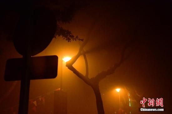 1月31日凌晨，市民行走在煙霧繚繞的南京街頭。當(dāng)天是農(nóng)歷馬年正月初一，南京有限開(kāi)禁燃放煙花爆竹正逢下霧天，空氣的不流通致使煙花爆竹燃燒后產(chǎn)生的顆粒物不能及時(shí)散開(kāi)，造成整座城市煙霧繚繞。據(jù)當(dāng)?shù)丨h(huán)保部門發(fā)布的信息顯示，空氣質(zhì)量屬重度污染。中新社發(fā) 泱波 攝