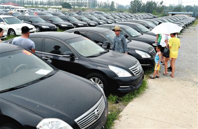 昨日，市民在山東棗莊一家拍賣公司場(chǎng)地上查看待拍賣公車。當(dāng)日，棗莊市103輛公車公開拍賣。新華社記者