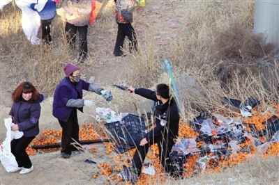 1月4日，連霍高速蘭州市榆中縣和平鎮(zhèn)段，一名警察舉著槍驅(qū)散哄搶橘子的村民。圖/CFP