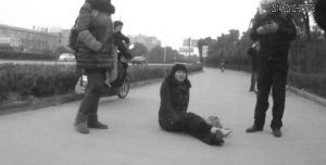 鄭大姐坐在地上，警方趕到進行施救。（視頻截圖由警方提供）