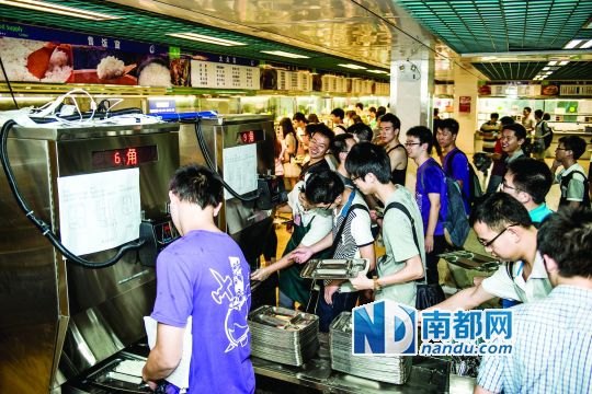 昨日，華南理工大學(xué)一食堂內(nèi)，學(xué)生們正在使用新安裝的自動打飯機(jī)打飯。中新社發(fā)