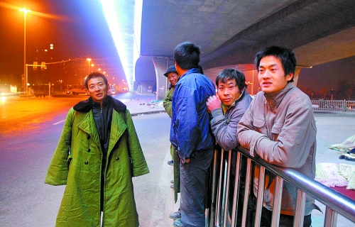 冬夜里，農民工在橋下等著干活兒。