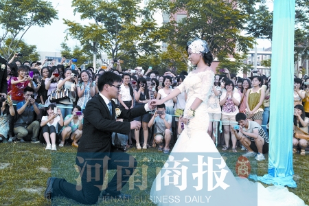 在學(xué)校操場的草坪上，兩名畢業(yè)生舉行婚禮，有同學(xué)感動地抹起眼淚