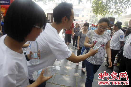 志愿者為剛剛考試完的考生送上1瓶冰凍的冰露·純悅，消暑解渴為考生加油