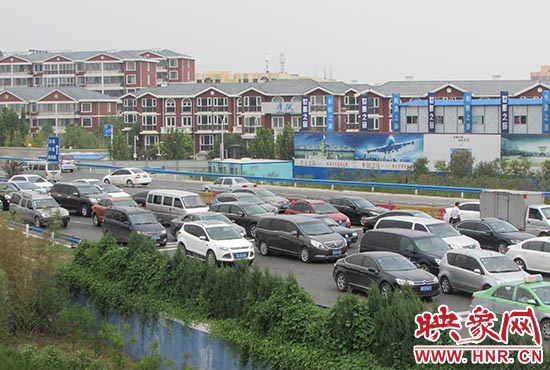記者看到鄭州機場收費站口車輛排隊，與此形成鮮明對比的是，路的對面（另一半幅）卻車輛較少，通行順暢。