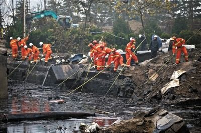 消防員在發現遺體的出事現場周邊搜尋是否還有遺體。