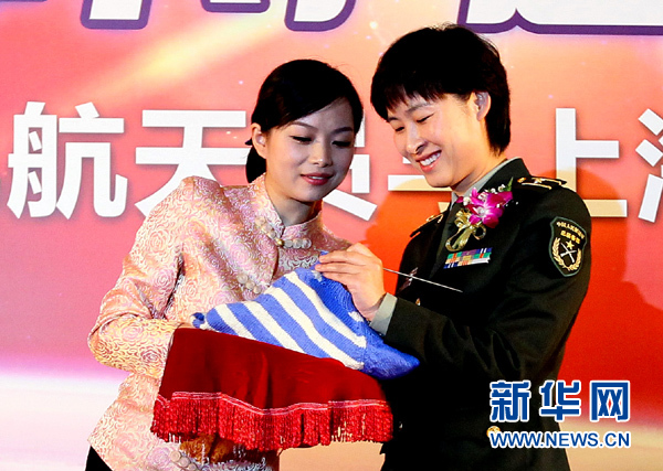 11月1日，航天員劉洋（右）在為“愛心”毛衣編織最后的收尾針。