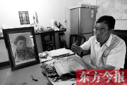 　魏樹紹手拿《物權(quán)法講義》手稿，在講訴先祖書寫“物權(quán)法”的歷史（相框里就是魏聯(lián)奎）
