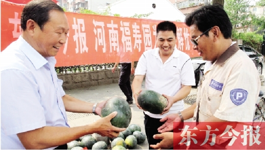 河南福壽園區(qū)域總經(jīng)理吳正宗（左一）、東方今報(bào)發(fā)行中心副總監(jiān)王路喜（中）在街頭給市民送瓜