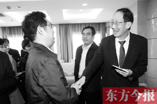 崔琦先生握手東方今報記者靳暉，感謝他把照片珍藏了15年