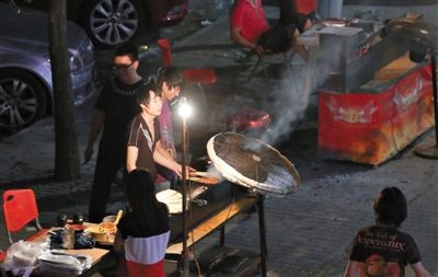 7月4日，青年路國(guó)美第一城小區(qū)附近的夜市臨街露天燒烤攤。