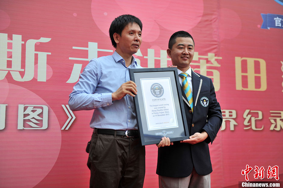 圖為世界吉尼斯認證官為鄭春輝（左）頒發證書。呂明 攝