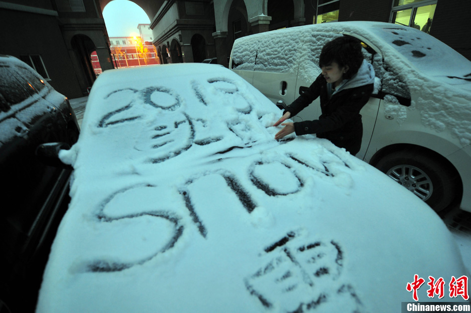 11月18日，行人在車輛的積雪上涂鴉。