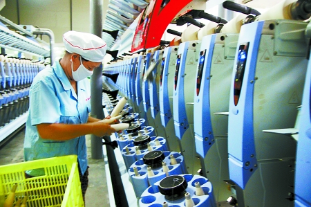 7月3日，在鄧州市永泰棉紡有限公司電腦控制全自動(dòng)紡紗車間，紡織工人正在生產(chǎn)棉紗。