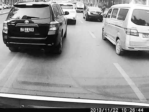 這輛黑色車輛不避讓執行緊急任務的救護車，并壓著雙黃線變更車道。唐韜/圖