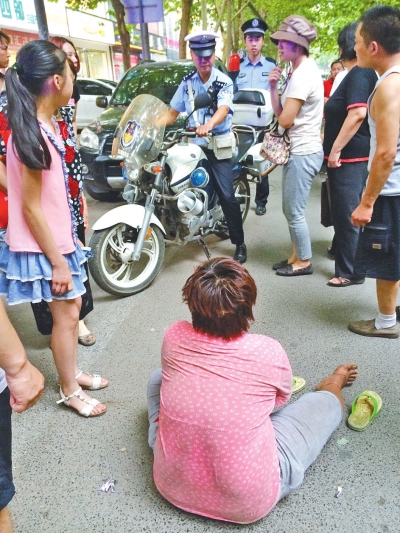 在鄭州優勝南路東三街交叉口向東100米處，一名短發中年女子平躺在路南快車道上，身旁還有一只掉落的拖鞋