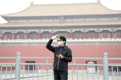 11月1日，北京大部分地區(qū)重度污染，一名游客戴著口罩在午門前揮手跟朋友打招呼。 實(shí)習(xí)生 王飛 攝