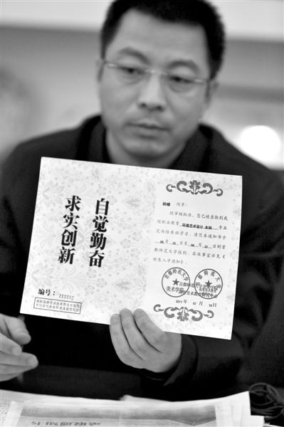 昨日，首師大美術(shù)學(xué)院黨委書(shū)記出示被騙學(xué)生的錄取通知書(shū)，表示“本科”字樣是由招生公司虛假宣傳、擅自添加。新京報(bào)記者 浦峰 攝