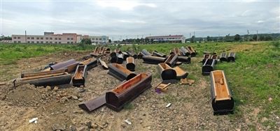 40多副棺木被砸壞后，扔在荒地上。