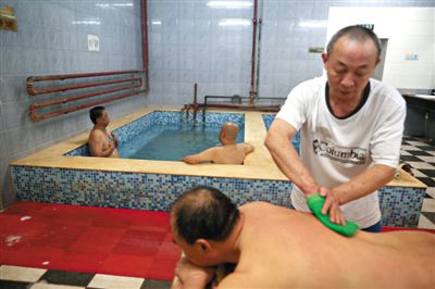 客人在搓澡。近日，百年歷史的鑫園浴池宣布將關(guān)張。新京報記者