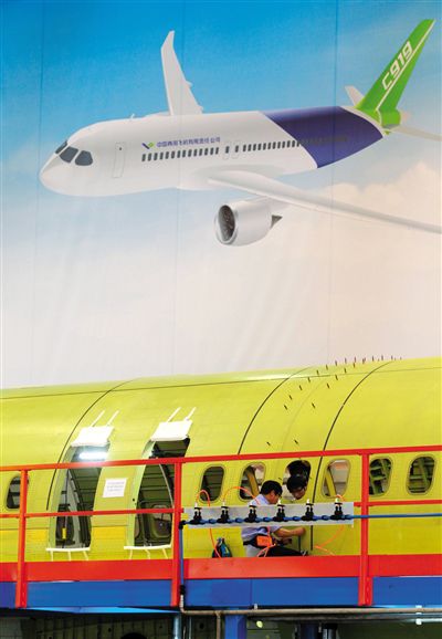昨日，中國商飛總裝制造中心技術人員對接C919首架機的機體。新華社記者 丁汀 攝