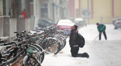 小伙子跪在樓前，一直抬頭看著樓上。 孫立國(guó)/攝
