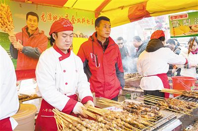 賣羊肉串?dāng)偽焕习遐w山（穿紅衣者）。新京報(bào)記者
