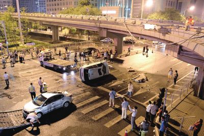 路虎沖下國貿橋砸中一輛起亞轎車，橋上厚達幾十厘米的水泥護欄被撞斷，碎石四處散落，數十群眾在現場圍觀。