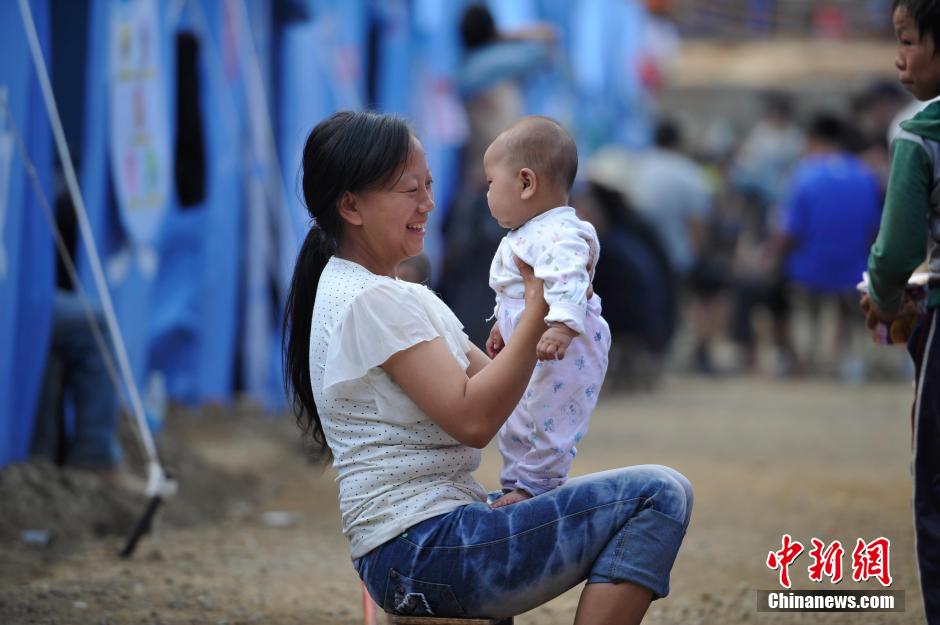 8月6日，一名年輕的母親在和孩子玩樂(lè)。
