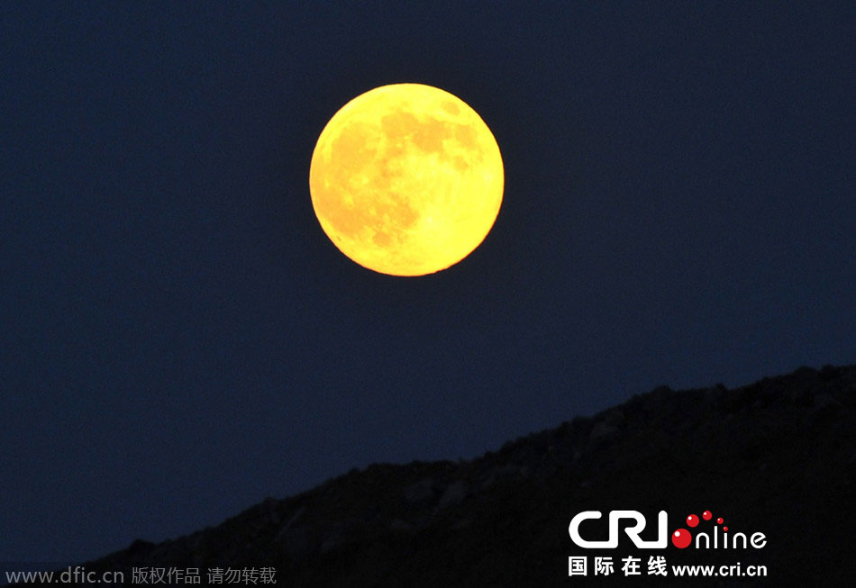 8月10日晚，一輪金燦燦的大月亮在遼寧省大連市東方升起。圖片來(lái)源：劉德斌/東方IC