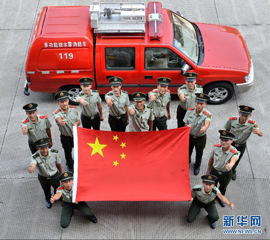  9月25日，武警浙江嘉興消防官兵與國(guó)旗合影。