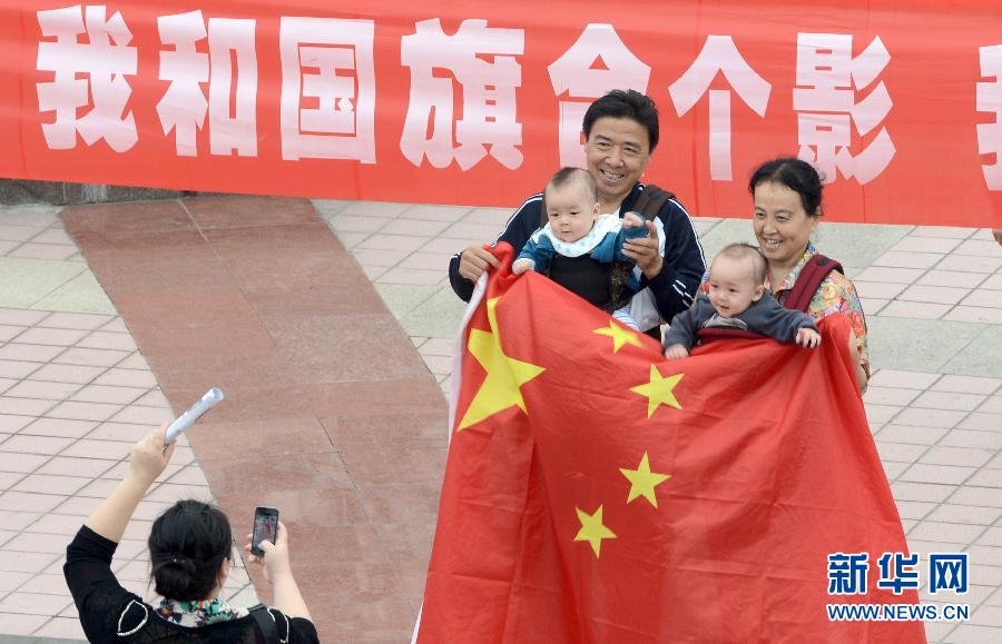 9月27日，在山東德州市中心廣場(chǎng)，市民與國(guó)旗合影。