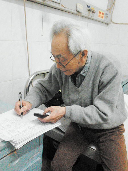杜修源老人埋頭寫著特殊的“日記”。 李卓 攝