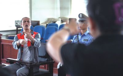 張志國在法庭上用手語回答提問。記者 蒲東峰攝