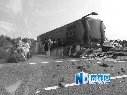 現場大客車側翻，玻璃碎落一地，車身卡在路邊水泥護欄上。 目擊者供圖