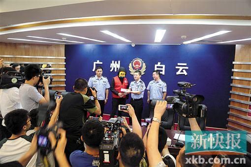 因舉報涉毒案件線索而獲獎的“快遞小哥”戴著面具領取獎金。