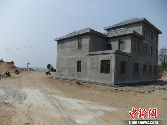 鴨河水庫庫區(qū)邊的新建別墅，一面墻上寫著“拆”，另一邊在加緊施工。吳揚(yáng)　攝