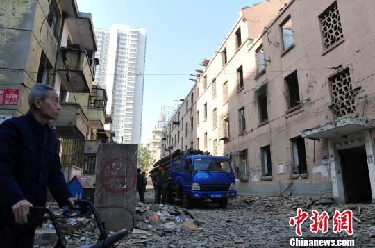 一位花甲老人站在即將拆除的樓房旁，默默地與“蘇聯樓”告別。　翟羽佳　攝